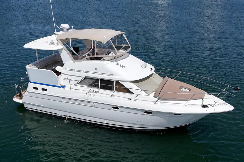 The Image of 1996 Cruisers Yachts 3650 Aft Cabin on calm water, showcasing sleek design and spacious deck. - 0