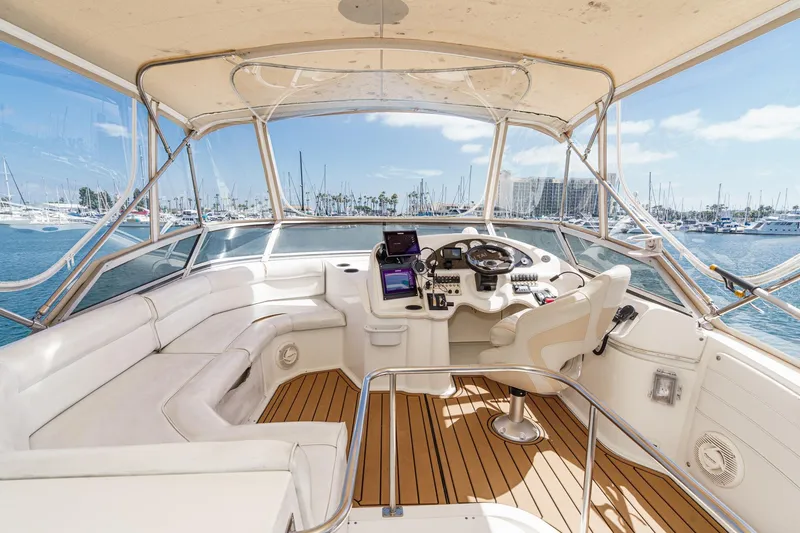 Slide: The Image of 1996 Cruisers Yachts 3650 Aft Cabin helm with marina view, featuring white seating and controls. - 14