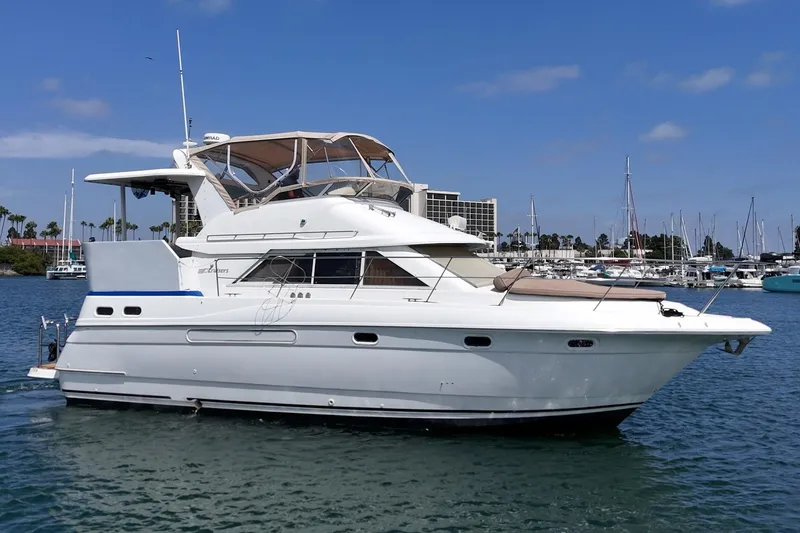 Slide: The Image of 1996 Cruisers Yachts 3650 Aft Cabin on water, marina background, clear sky. - 2