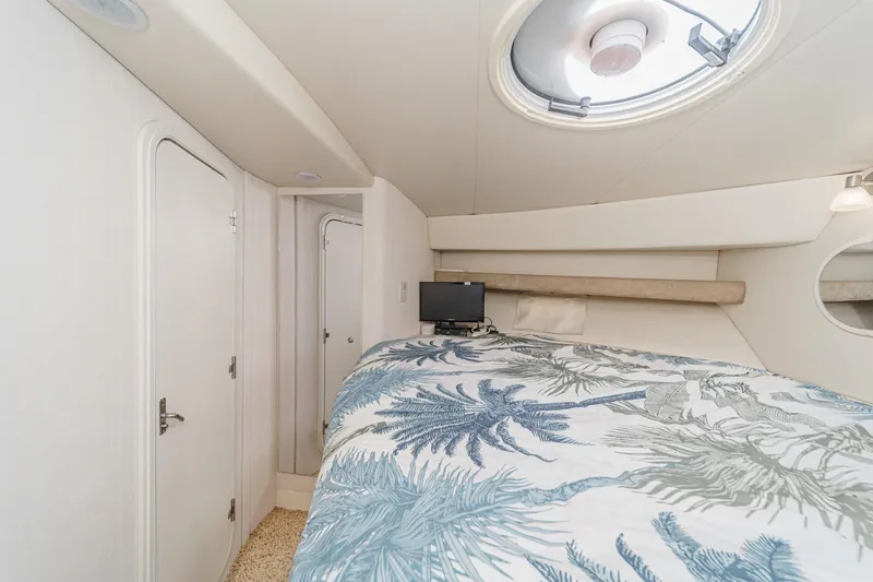 Slide: The Image of 1996 Cruisers Yachts 3650 Aft Cabin interior with bed, porthole, and tropical bedding. - 41