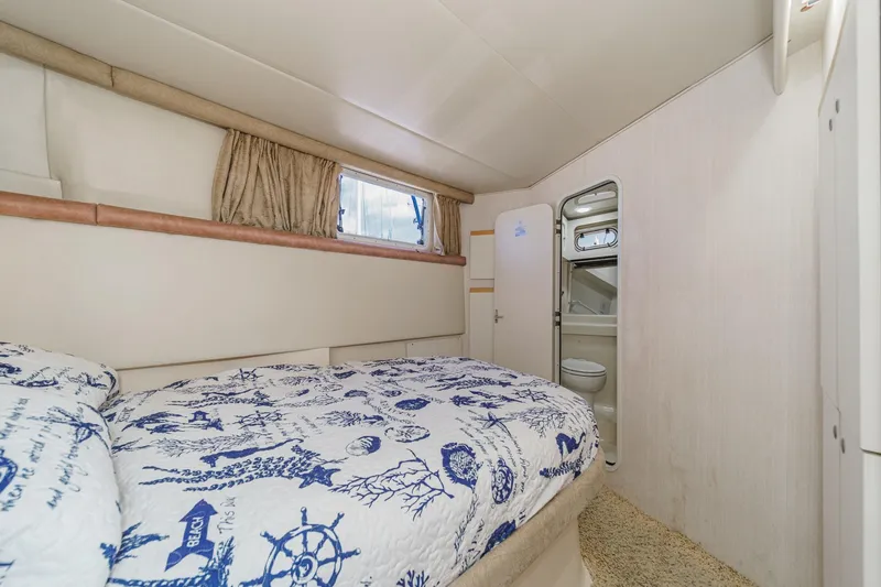 Slide: The Image of 1996 Cruisers Yachts 3650 Aft Cabin bedroom with nautical-themed bedding and ensuite bathroom. - 42