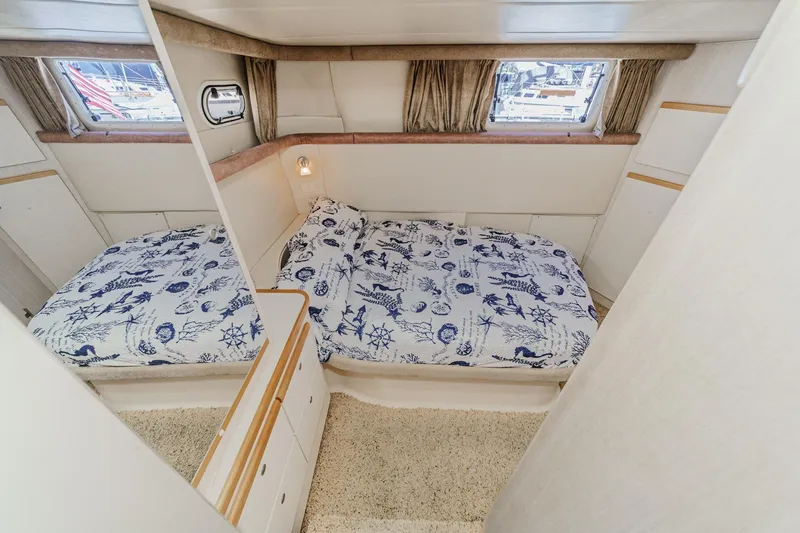 Slide: The Image of 1996 Cruisers Yachts 3650 Aft Cabin bedroom with nautical-themed bedding and porthole windows. - 45