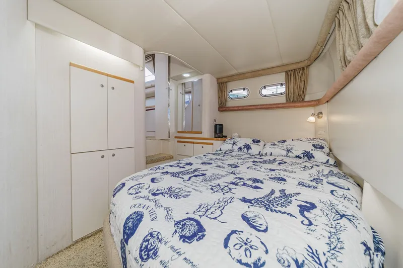 Slide: The Image of 1996 Cruisers Yachts 3650 Aft Cabin bedroom with nautical-themed bedding and cozy interior. - 46