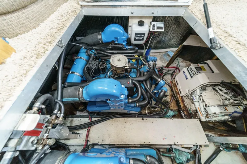Slide: The Image of Engine compartment of a 1996 Cruisers Yachts 3650 Aft Cabin, featuring blue engine components. - 52