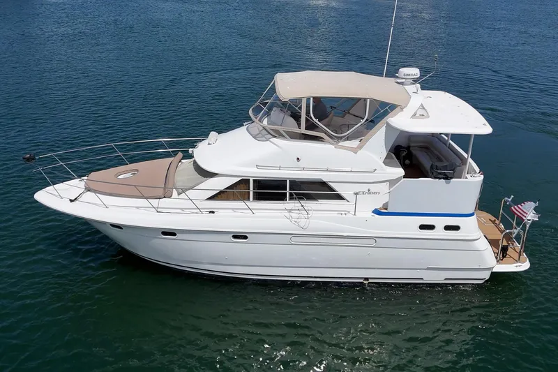 Slide: The Image of 1996 Cruisers Yachts 3650 Aft Cabin on calm water, showcasing sleek design and spacious deck. - 6