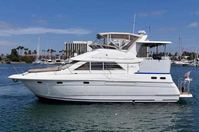 Slide: The Image of 1996 Cruisers Yachts 3650 Aft Cabin on water, marina background, clear sky. - 7
