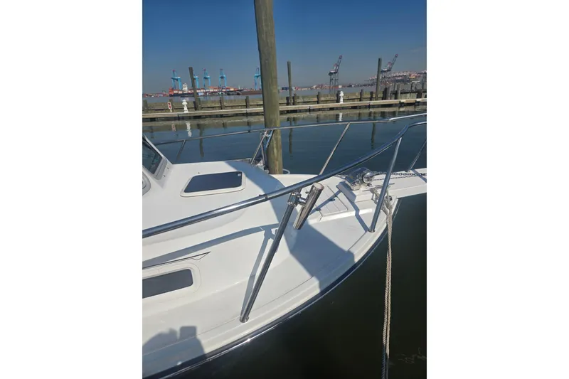 Slide: The Image of 2022 Parker 2120 Sport Cabin boat docked at marina, clear sky background. - 10