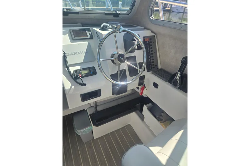 Slide: The Image of Interior of 2022 Parker 2120 Sport Cabin boat with steering wheel and Garmin equipment. - 12