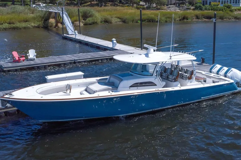 Slide: The Image of 2025 Valhalla Boatworks V-46 docked, sleek design, blue hull, luxury features. - 1