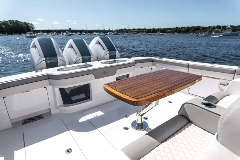 Slide: The Image of 2025 Valhalla Boatworks V-46 luxury deck with wooden table and powerful engines. - 17