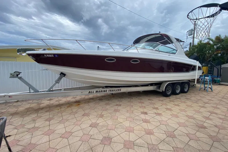 Slide: The Image of 2009 Formula 330 Sun Sport boat on trailer, parked on a paved driveway. - 1