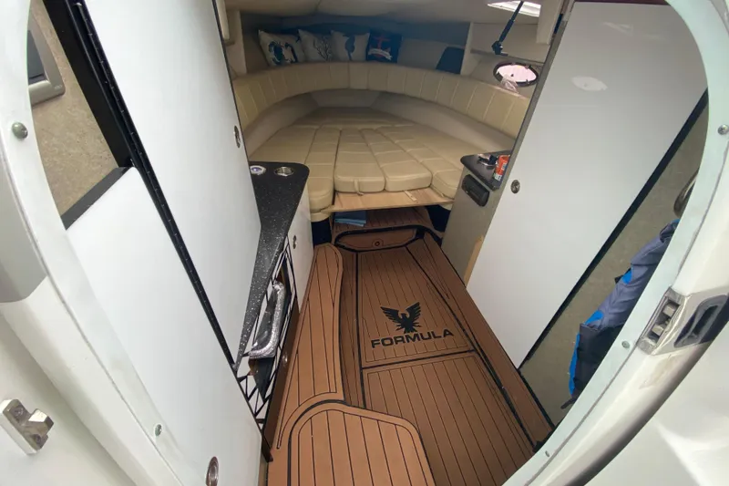 Slide: The Image of 2009 Formula 330 Sun Sport cabin interior with beige seating and wood-style flooring. - 20