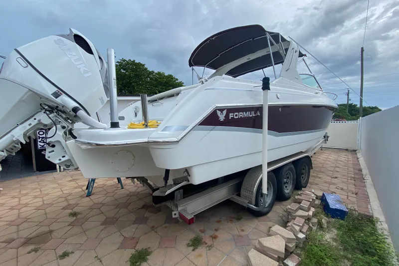 Slide: The Image of 2009 Formula 330 Sun Sport boat on trailer, featuring Suzuki outboard engines. - 27