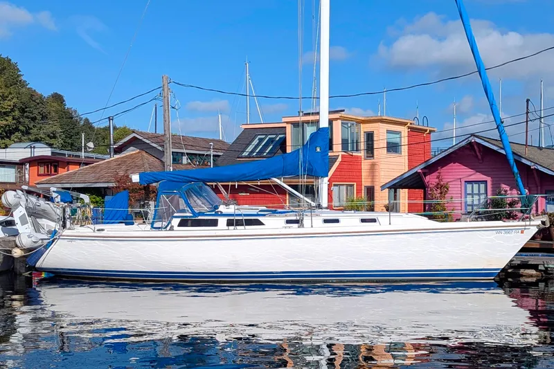 Slide: The Image of Catalina 42 sailboat from 1990 docked near colorful waterfront houses. - 0
