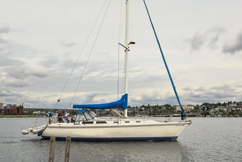 Slide: The Image of 1990 Catalina 42 sailboat on calm water with cloudy sky backdrop. - 1