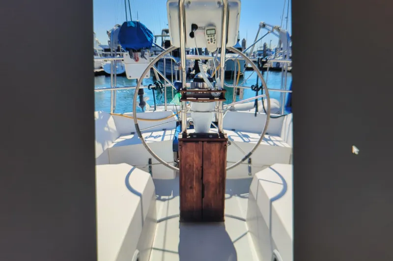 Slide: The Image of Cockpit of a 1990 Catalina 42 sailboat with steering wheel and navigation equipment. - 10