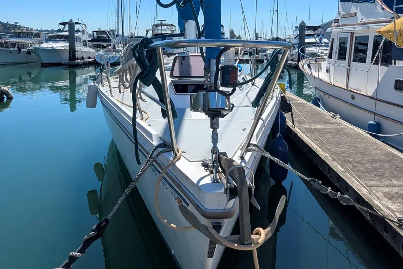 Slide: The Image of 1990 Catalina 42 sailboat docked in a marina, surrounded by other boats. - 2