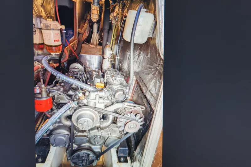 Slide: The Image of Engine compartment of a 1990 Catalina 42 sailboat, showcasing mechanical components. - 21