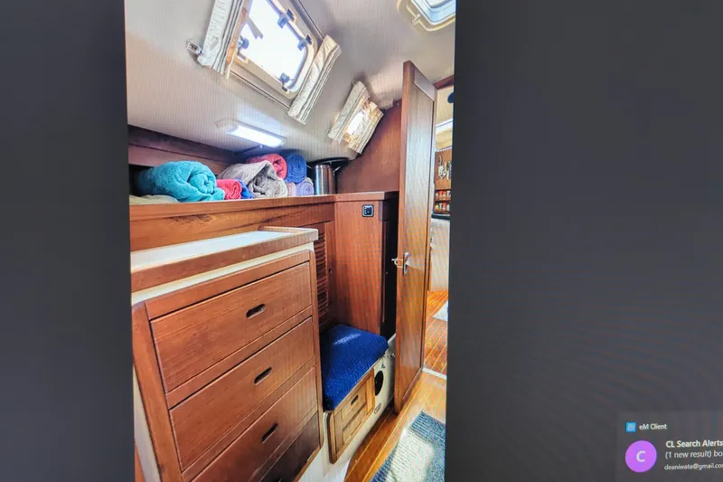 Slide: The Image of Interior of 1990 Catalina 42 sailboat with wooden cabinetry and colorful towels. - 24