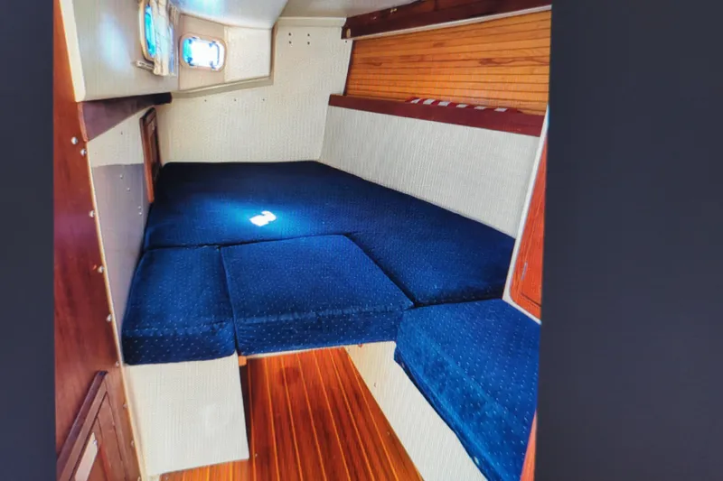 Slide: The Image of Interior cabin of a 1990 Catalina 42 sailboat with blue cushions and wood paneling. - 27