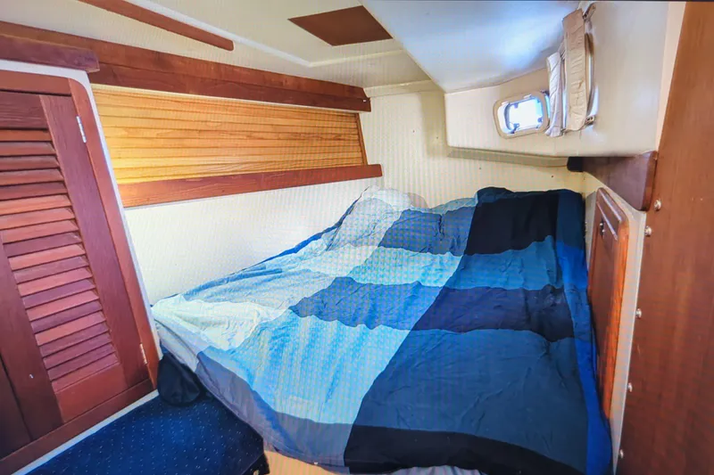 Slide: The Image of Cozy cabin interior of 1990 Catalina 42 sailboat with bed and wooden accents. - 28