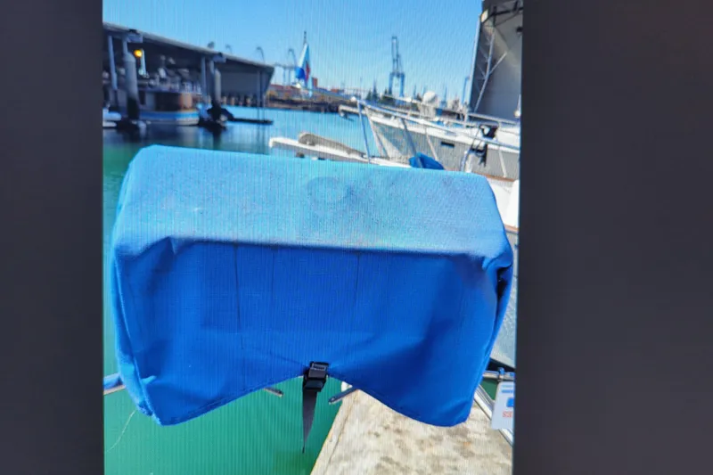 Slide: The Image of Blue-covered equipment on a 1990 Catalina 42 sailboat docked at a marina. - 30