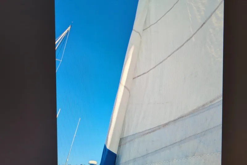 Slide: The Image of Sail of a 1990 Catalina 42 yacht against a clear blue sky. - 32