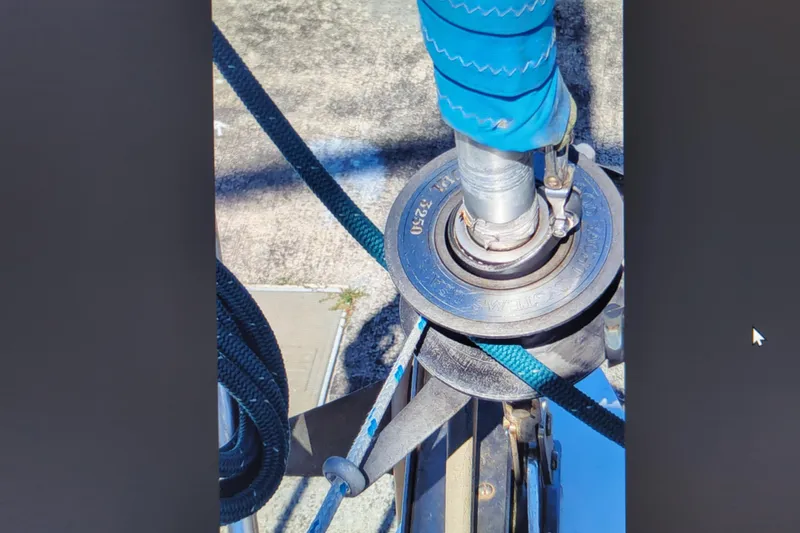 Slide: The Image of Close-up of Catalina 42 sailboat rigging, featuring a winch and blue rope, 1990 model. - 33