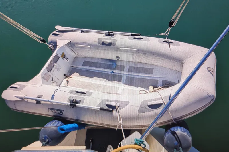 Slide: The Image of Inflatable dinghy on a 1990 Catalina 42 sailboat, secured with ropes. - 35
