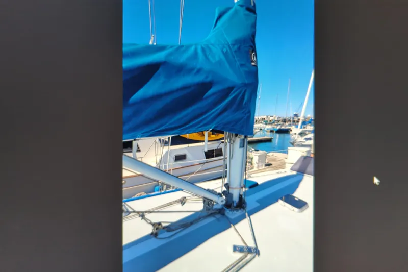 Slide: The Image of Sailboat deck view of a 1990 Catalina 42 in a marina, featuring a covered mast. - 37