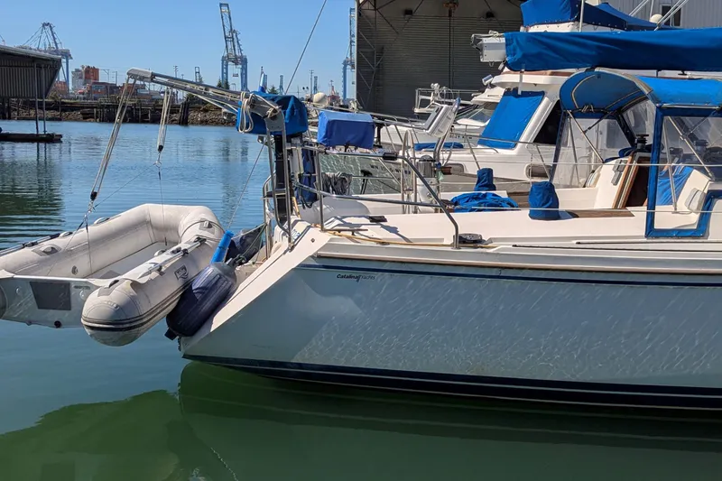 Slide: The Image of Catalina 42 sailboat from 1990 docked with inflatable dinghy attached. - 8