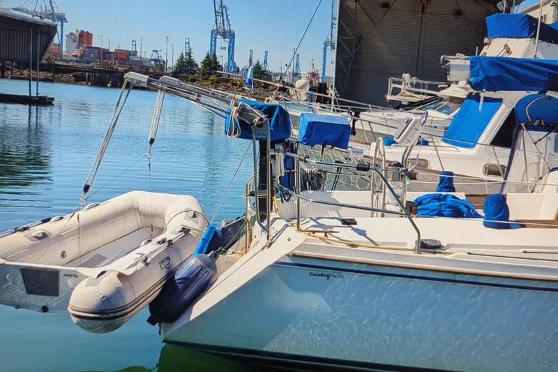 Slide: The Image of Sailboat Catalina 42 (1990) docked with inflatable dinghy, industrial background. - 9