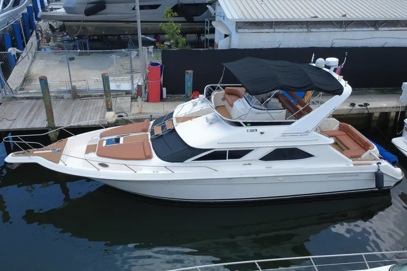 Slide: The Image of 1997 Sea Ray 450 Express Bridge yacht docked, featuring sleek design and spacious deck. - 2