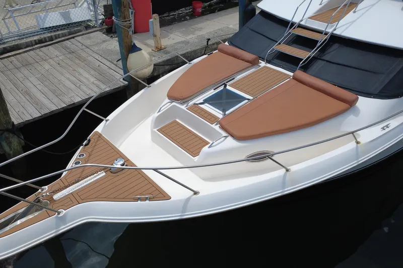 Slide: The Image of 1997 Sea Ray 450 Express Bridge yacht with sun pads and teak decking at dock. - 4