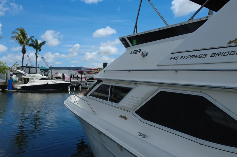 Slide: The Image of 1997 Sea Ray 450 Express Bridge yacht docked in a marina under a clear blue sky. - 6