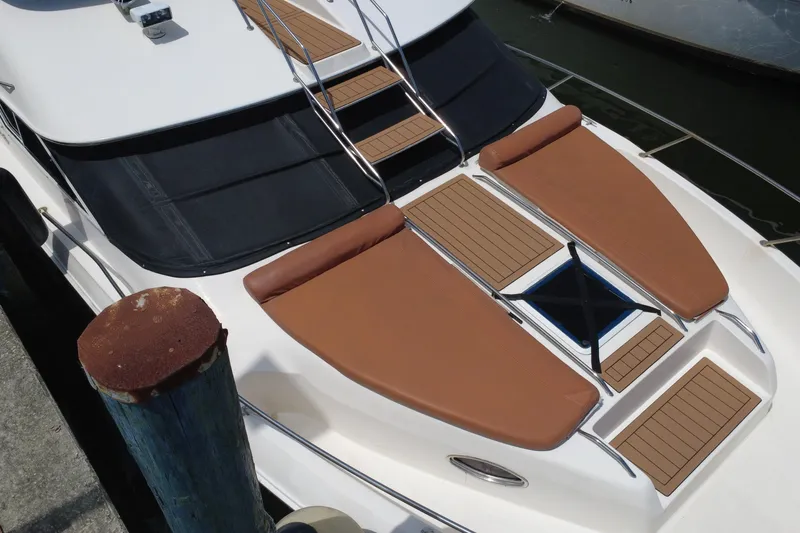 Slide: The Image of 1997 Sea Ray 450 Express Bridge yacht with brown sun pads and sleek design. - 8