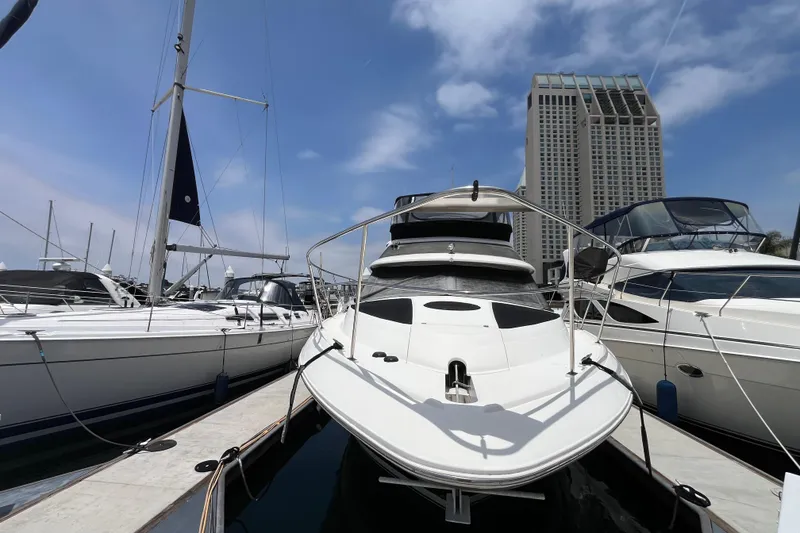 Slide: The Image of 1995 Cruisers Yachts 3650 Motoryacht docked at marina with skyscraper backdrop. - 1