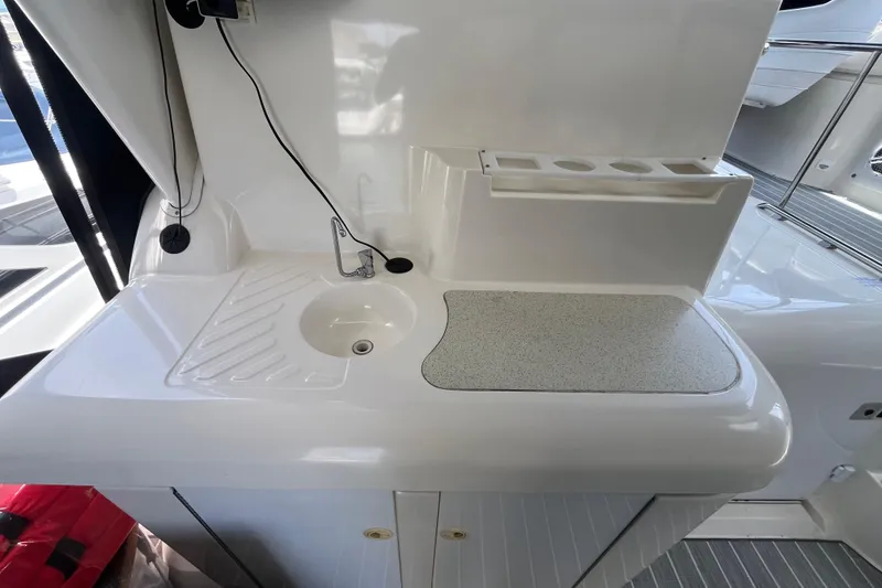 Slide: The Image of 1995 Cruisers Yachts 3650 Motoryacht kitchenette with sink, counter, and cup holders. - 13