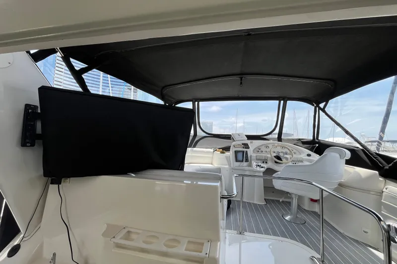 Slide: The Image of 1995 Cruisers Yachts 3650 Motoryacht helm with modern controls and seating under canopy. - 14