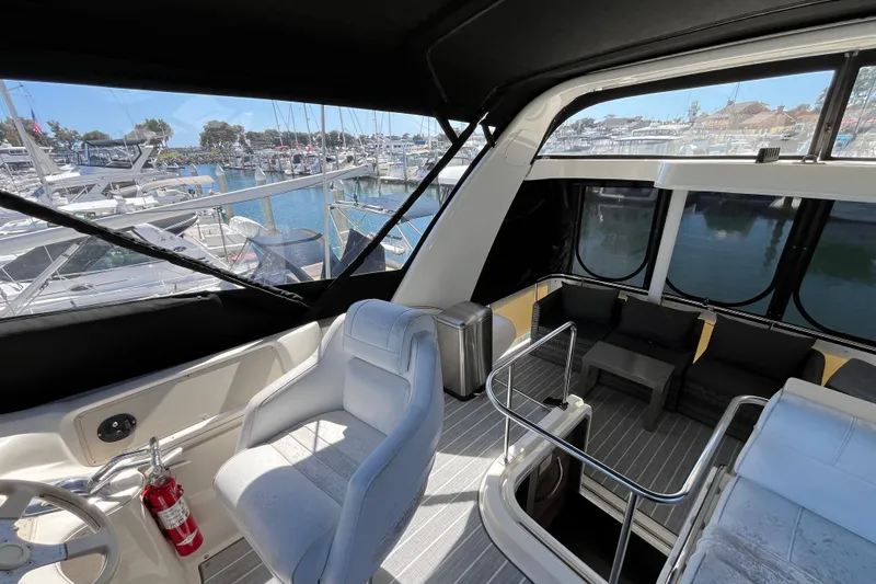Slide: The Image of 1995 Cruisers Yachts 3650 Motoryacht interior with marina view, featuring seating and helm. - 22