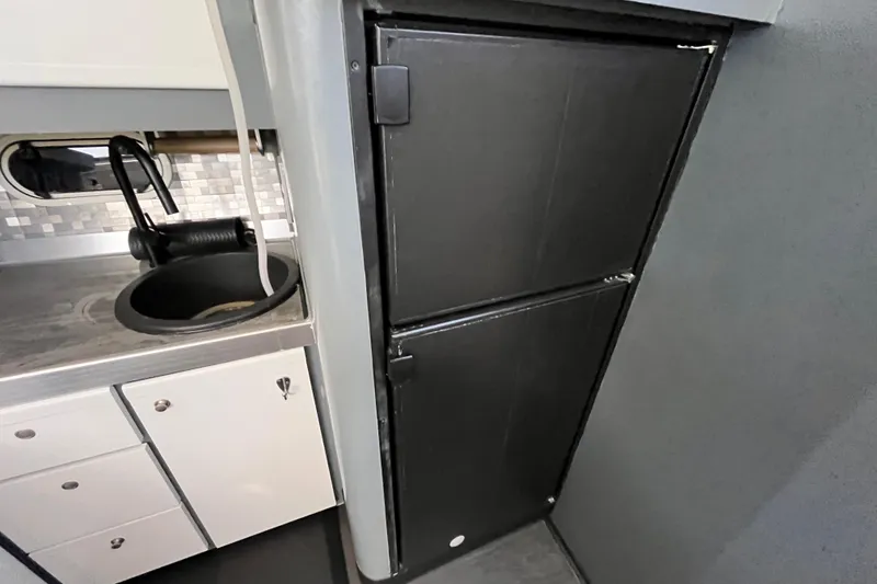 Slide: The Image of 1995 Cruisers Yachts 3650 Motoryacht kitchen with sink and black refrigerator. - 32