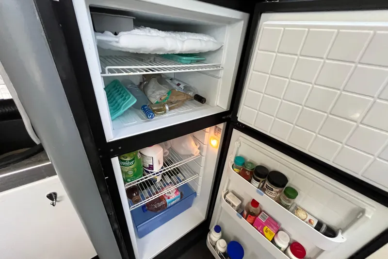 Slide: The Image of Open refrigerator in 1995 Cruisers Yachts 3650 Motoryacht, stocked with various food items and condiments. - 33