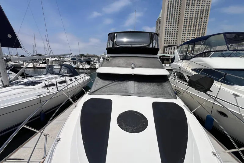 Slide: The Image of 1995 Cruisers Yachts 3650 Motoryacht docked at marina, surrounded by other boats. - 4