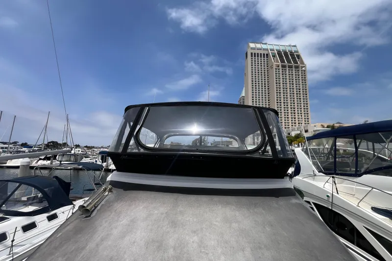 Slide: The Image of 1995 Cruisers Yachts 3650 Motoryacht docked at marina with cityscape backdrop. - 6