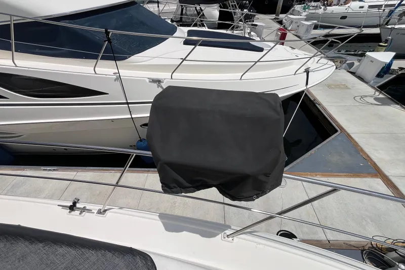 Slide: The Image of 1995 Cruisers Yachts 3650 Motoryacht docked, featuring covered equipment on deck. - 7