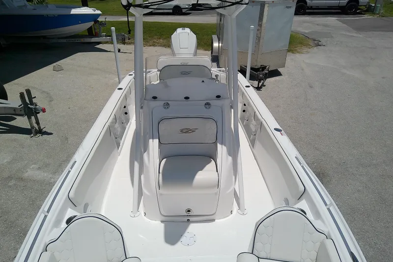 Slide: The Image of 2025 Glasstream 240 CCX boat interior with white seating and console, parked on pavement. - 13