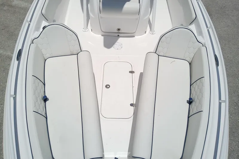 Slide: The Image of 2025 Glasstream 240 CCX boat interior with white cushioned seating and storage compartment. - 14