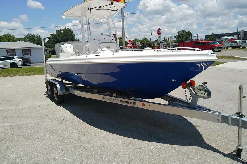 Slide: The Image of 2025 Glasstream 240 CCX boat on trailer, parked outdoors under a sunny sky. - 2