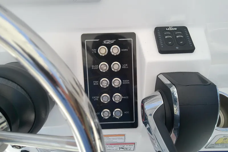 Slide: The Image of Control panel of 2025 Glasstream 240 CCX boat with steering wheel and switches. - 21