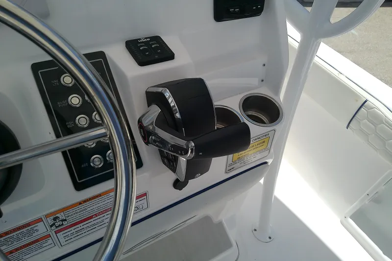 Slide: The Image of 2025 Glasstream 240 CCX boat dashboard with steering wheel, controls, and cup holders. - 22